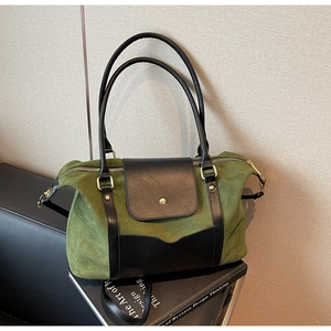 Détail du cabas vintage vert mat avec poignées en cuir noir et fermeture éclair dorée