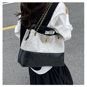 Detailed top view of large quilted tote bag featuring gold clasp and chain strap