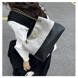 Detail of grey suede and black quilted leather tote with gold metal chain strap