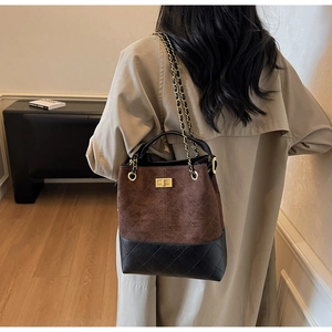 Detail of vintage suede bucket bag with quilted patterns and gold twist lock closure
