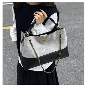 Detail of grey suede and black quilted leather tote with gold twist lock and chain strap