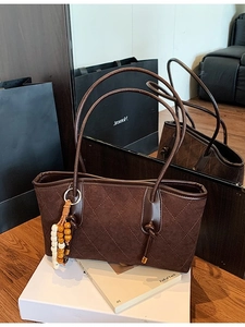 Quilted dark coffee shoulder bag with tassel charm and elegant suede texture