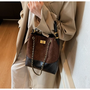 Detail of the quilted bucket bag showing mixed brown suede and black stitched leather textures