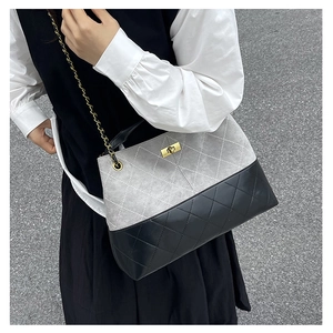 Detail of grey suede and black quilted leather shoulder bag with gold twist-lock closure