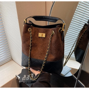 Detail of the vintage suede patchwork bucket bag featuring quilted diamond pattern and chain