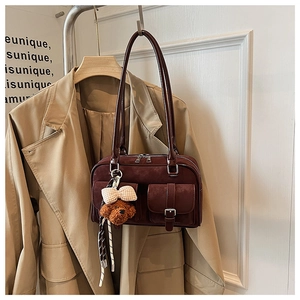 Detail of dark brown vintage Boston shoulder bag with cute bear charm and pocket