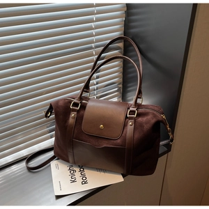 Détail du cabas en daim marron foncé avec rabat en cuir et finitions dorées