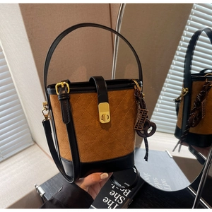 Detail of vintage suede bucket bag with diamond stitching and unique abacus charm