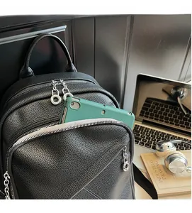 Detail showing high-capacity black litchi pattern backpack front pockets with a tablet