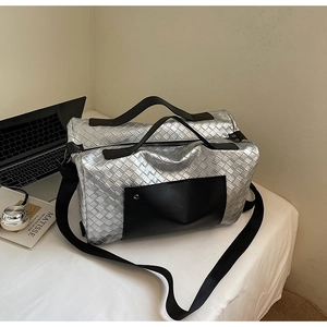 Dettaglio della borsa da viaggio intrecciata argento con tasche in pelle e tracolla regolabile
