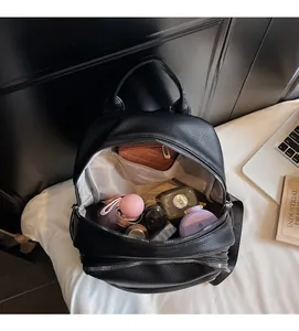 Spacious interior of black lychee leather backpack with dual zipper compartments