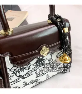 Detail of New Chinese style handbag with landscape print and golden floral clasp
