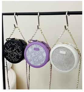 Detailed view of three circular crossbody bags with floral embroidery and pearl chain straps