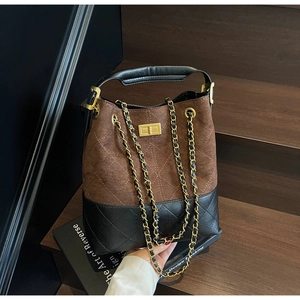 Close-up of vintage suede bucket bag featuring brown quilting and gold twist lock
