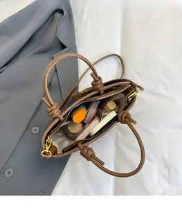 Top view showing the large interior capacity and knot handle detail of the brown bucket bag