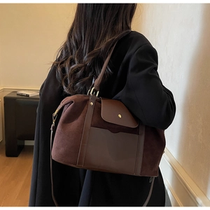 Détail du grand sac cabas en daim mat vintage porté par un mannequin en blazer