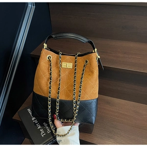 Detail of vintage suede bucket bag with quilted patterns and gold twist lock closure