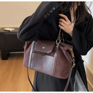 Détail d'un sac cabas marron foncé montrant le mélange de textures et la boucle dorée