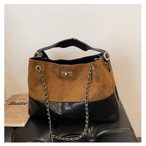 Detail of suede and quilted leather tote bag with gold twist lock and chain strap