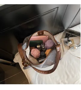 Spacious interior of a grey fabric tote bag with brown leather handles and magnetic closure