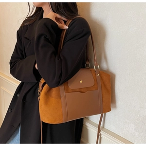 Détail du sac fourre-tout en daim marron rétro avec anneaux en métal et bandoulière