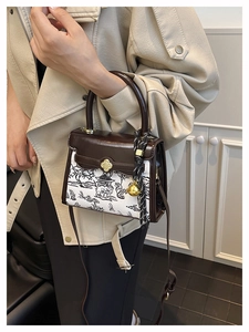 Detailed view of vintage crossbody bag with gold clover lock and woven rope accessory