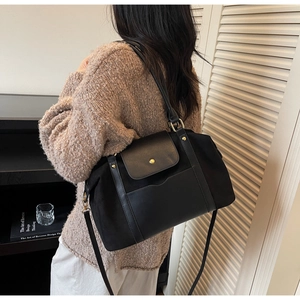 Modèle portant un sac cabas noir givré avec détails dorés et bandoulière amovible