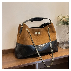 Detail of vintage suede tote bag showing patchwork design and metal twist-lock closure