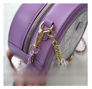 Detail of the golden lobster clasp and chain with decorative pearls on the purple bag