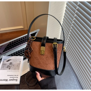 Detail of vintage quilted bucket bag with gold clasp and suede leather patchwork textures