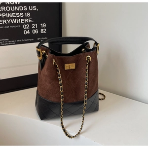 Detailed close-up of vintage brown suede and black leather bucket bag with quilted patterns