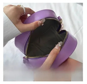 Detail view of the spacious dark grey fabric interior and golden zipper of this round bag