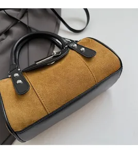 Détail du sac seau léopard avec finition en daim marron et garniture en cuir noir