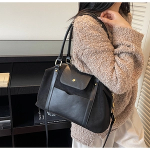 Grand sac à main noir mat pour femme porté par un mannequin avec un pull en maille
