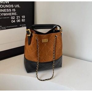 Detail of vintage bucket bag featuring quilted suede texture and gold twist-lock closure
