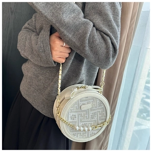 Detail view of round pearl chain bag with geometric weaving and gold accents