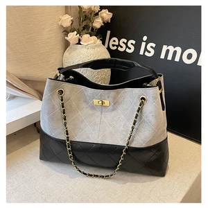 Detailed view of bicolor suede tote with quilted stitching and gold twist lock