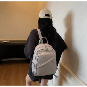 Beige faux leather backpack with pebbled texture shown on model for urban commute