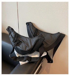 Detail der schwarzen Nylon-Halbmondtasche mit Seil-Reißverschluss und verstellbarer Schnalle