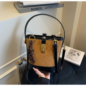 Detail of vintage brown bucket bag with quilted stitching and gold twist lock