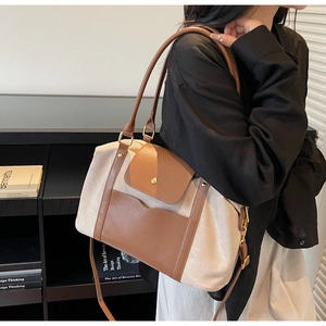 Détail du sac cabas en toile et cuir marron avec poche avant vue de côté sur modèle