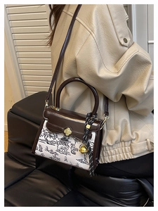 Detail of a vintage contrast crossbody bag featuring floral clasp and printed fabric panel