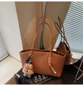 Détail du sac cabas tissé marron foncé avec motif à chevrons et breloque chien en peluche
