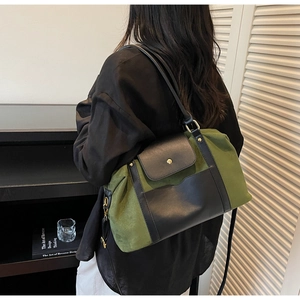 Gros plan d'un sac à bandoulière mat vert olive porté par un mannequin en décor minimaliste