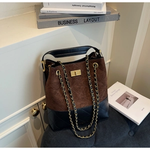 Detail of vintage suede bucket bag with quilted leather, gold twist lock and chain strap