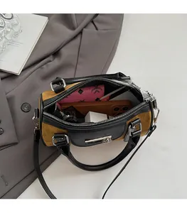 Vue intérieure d'un petit sac Boston en daim montrant l'espace pour téléphone et maquillage