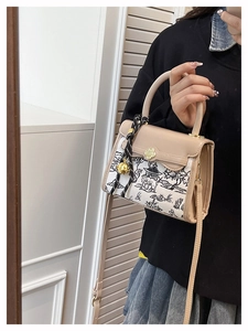 Detail of beige leather bag with ink painting panel and gold floral clasp decor