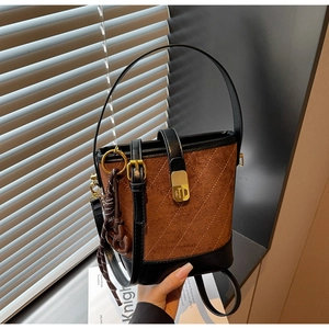 Detail of vintage brown suede bucket bag with diamond quilting and gold lock