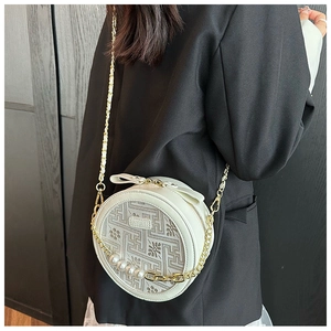 Detail of white round crossbody bag with vintage embroidery pattern and pearl chain strap
