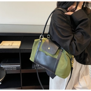 Détail du sac à bandoulière en toile verte avec rabat en cuir noir et boucle dorée